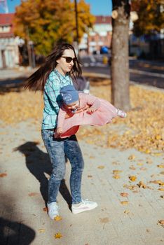 happy family mother and child little daughter running and playing on autumn walk