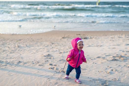 Adorable toddler girl on a sunny sand beach. Childhood