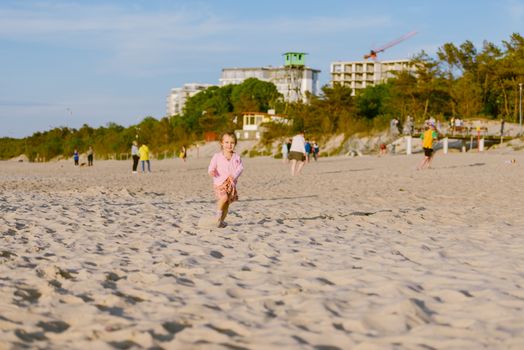 Adorable toddler girl on a sunny sand beach. Childhood