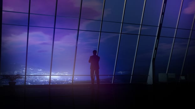 Male silhouette in a business suit on the background of an office window with a view of the night coastal city.