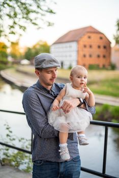 Happy loving family. Father and his daughter child girl playing and hugging outdoors. Cute little girl hugs daddy. Concept of Father's day.