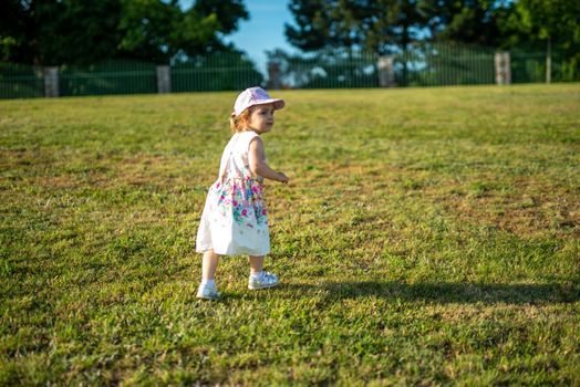 Smiling girl in the park in summer time. Authentic lifestyle image
