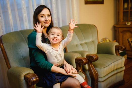 Happy mother and daughter in the park. Beauty nature scene with family outdoor lifestyle. Happy family resting together on the green grass, having fun outdoor. Happiness and harmony in family life.