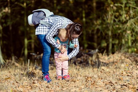 happy family mother and child little daughter running and playing on autumn walk