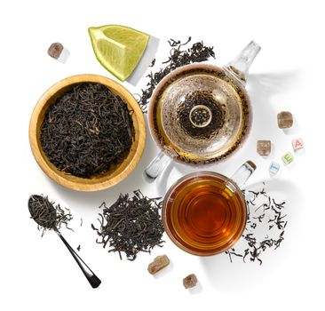 Black tea and accessories top view on white background.