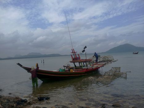 fisherman prepare their boat for fishing near the beach