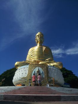 People are paying homage to buddha image with the blue sky background. Sai Thang Temple, Prachuap Khiri Khan.