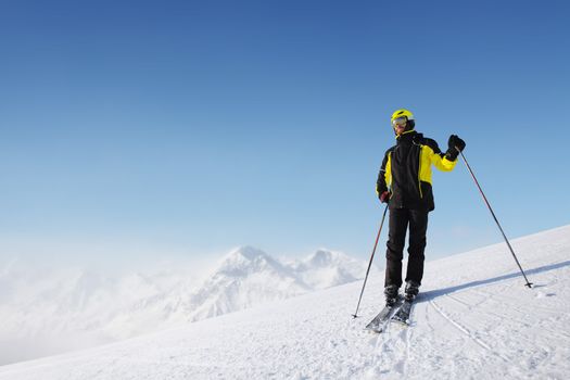 Skier standing alone and looking at panoramic view at Alps mountains