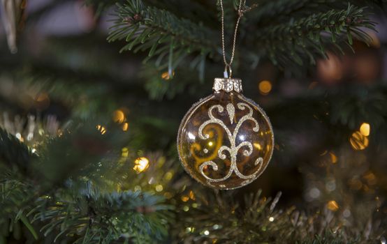 golden christmas ball in the tree as a christmas card during the december season