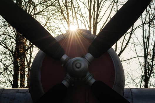 propeller of a vintage airplane in the rays of the evening sunset close up
