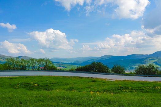 View of the mountain road, blue sky, mountains on the horizon