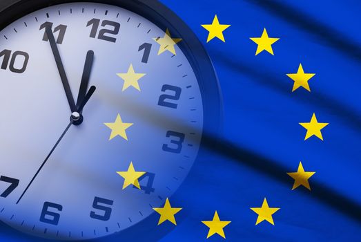 Composite of the EU flag and dial of a clock counting down to twelve in a concept of deadlines and urgency for Brexit