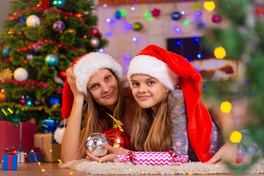 Girl and child lie on the mat in the New Year's interior