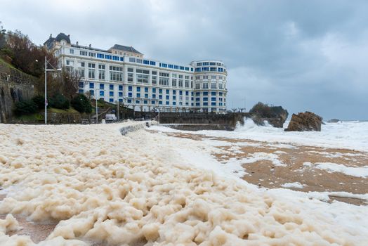 Foam on the Grande Plage beach and its quay during a storm, France