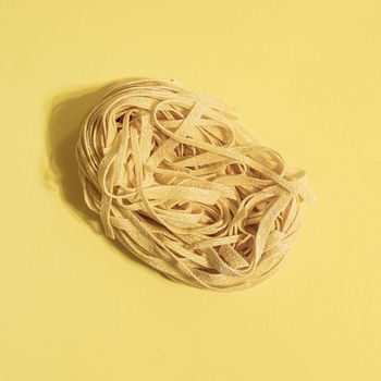 A "nest" of typical fresh egg pasta on a colored surface