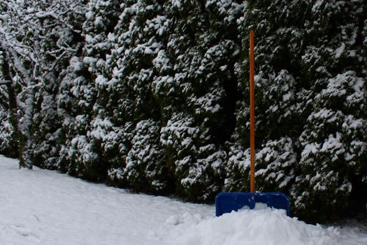The picture shows a snow shovel in the snow