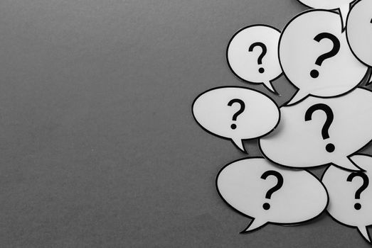 Question marks on speech bubbles side border over a gray background with copy space in a communications concept