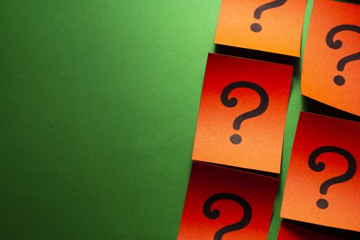 Side border of red cards with question marks arranged in rows on a green background with copy space