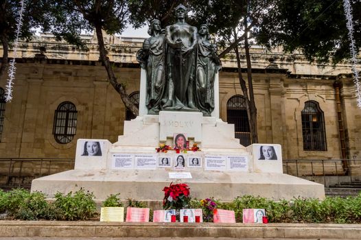 VALLETTA, MALTA - NOVEMBER 28, 2019:Flowers, candles and tributes to Daphne Caruana Galizia at the foot of the Great Siege Monument at Valletta, Malta.