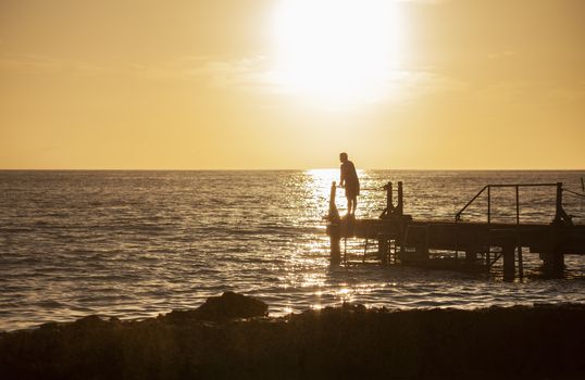 Fisherman on the pier at sunset in Bayahibe in the Dominican Republic