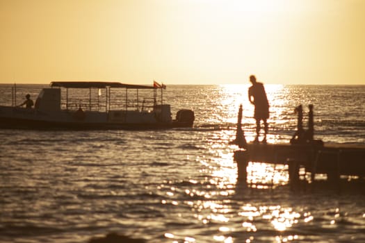 Fisherman on the pier at sunset in Bayahibe in the Dominican Republic