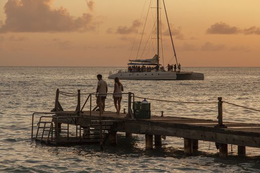 People on the pier at sunset in Bayahibe, Dominican Republic