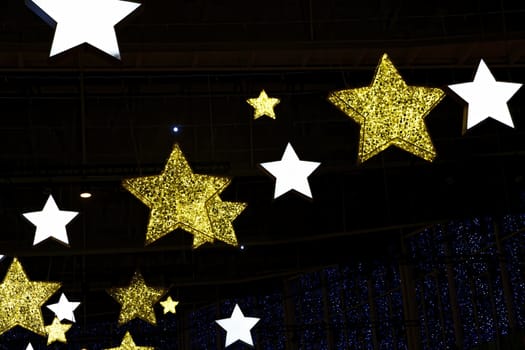 Festive Christmas decoration is a glowing yellow and white light of the stars