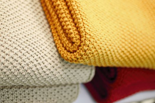Red, beige and yellow knitted blankets. Cozy and warm in the winter season.