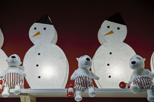 New Year's fun snowmen and Christmas soft toys on a maroon background.