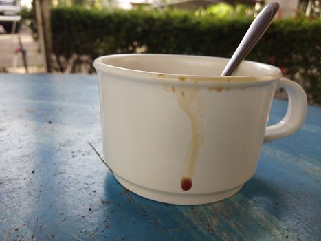 The coffee stains on a cup that on the table.