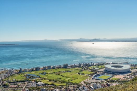 An aerial view of Green Point in Cape Town as seen from Signal Hill. The Cape Town Stadium and other sport facilities are visible. Robben Island is visible