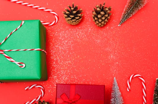 New Year, Christmas Xmas holiday composition, Top view green and red gift box, clews of rope, green fir tree branch on red background with copy space
