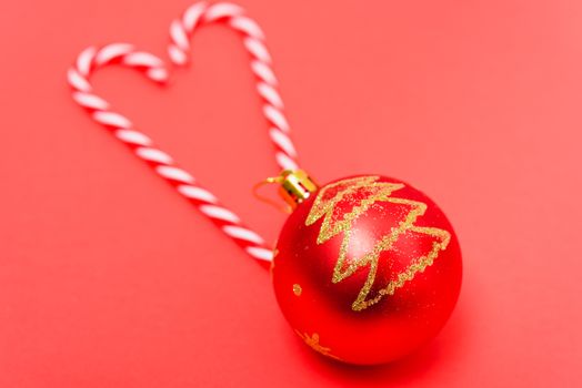 Two candy canes made making Heart of Christmas candies on red background with copy space