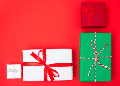 Happy New Year and Christmas 2020 day, top view Xmas multi color gift boxes on red background with copy space for your text