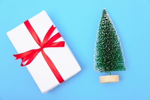 Happy New Year and Christmas 2020 or valentine day, top view craft paper wrapped present gift box craft and fir tree on blue background with copy space for your text