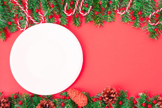 Happy New Year and Christmas day, top view flat lay composition decoration tree fir and white round on red background with copy space for your text