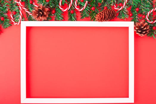 Happy New Year and Christmas day, top view flat lay composition decoration tree fir and photo frame on red background with copy space for your text