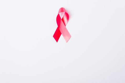 Breast cancer month concept, flat lay top view, pink ribbon on white background with copy space for your text