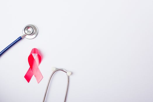 Breast cancer month concept, flat lay top view, pink ribbon and stethoscope on white background with copy space for your text