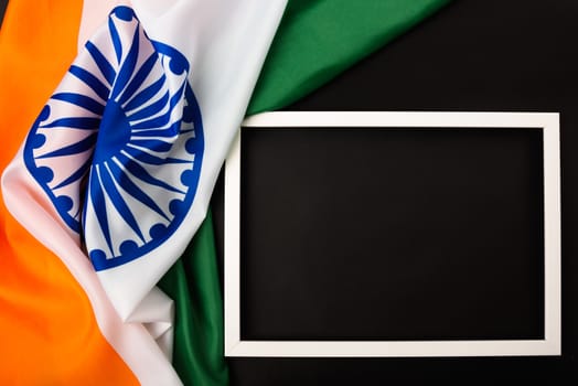Indian republic day, flat lay top view, Indian flag and photo frame on black background with copy space for your text