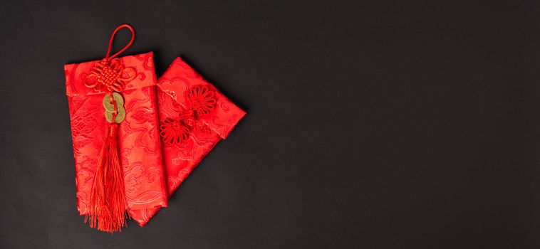 Chinese new year festival concept, flat lay top view, Happy Chinese new year with Red envelope (Character "FU" means fortune, blessing, wealth) on black background with copy space for your text