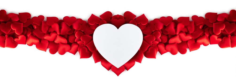 Valentine's day many red silk hearts and white heart shaped card isolated on white background, love concept
