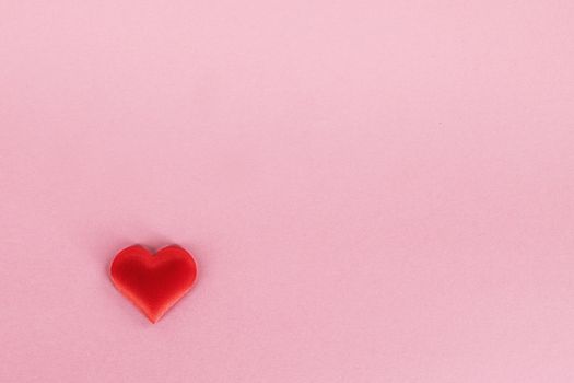 Valentine's day red silk heart on pink paper background, love concept