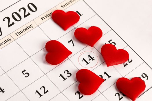 Valentine's day red silk hearts on calendar with 14 february date background, love, celebration concept