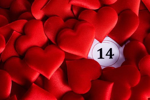 Valentine's day red silk hearts on calendar with 14 february date background, love, celebration concept