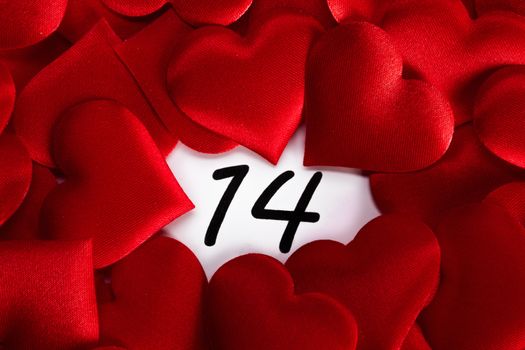 Valentine's day red silk hearts on calendar with 14 february date background, love, celebration concept