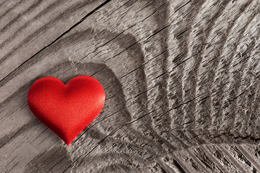 Valentine's day red silk heart on wooden background, love concept