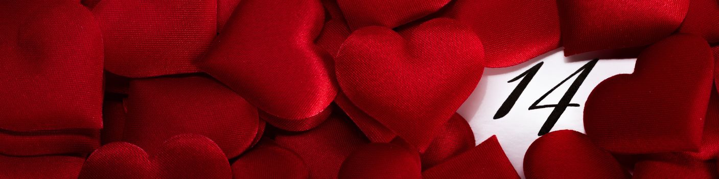 Valentine's day red silk hearts on calendar with 14 february date background, love, celebration concept