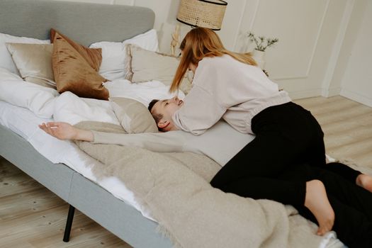 Business couple on bed in hotel room - tender hugs