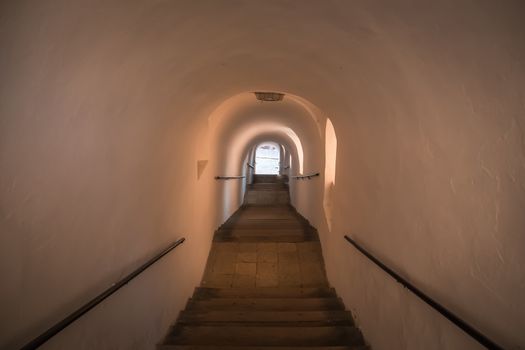 An ancient staircase inside the tunnel leads up. There are stone steps.